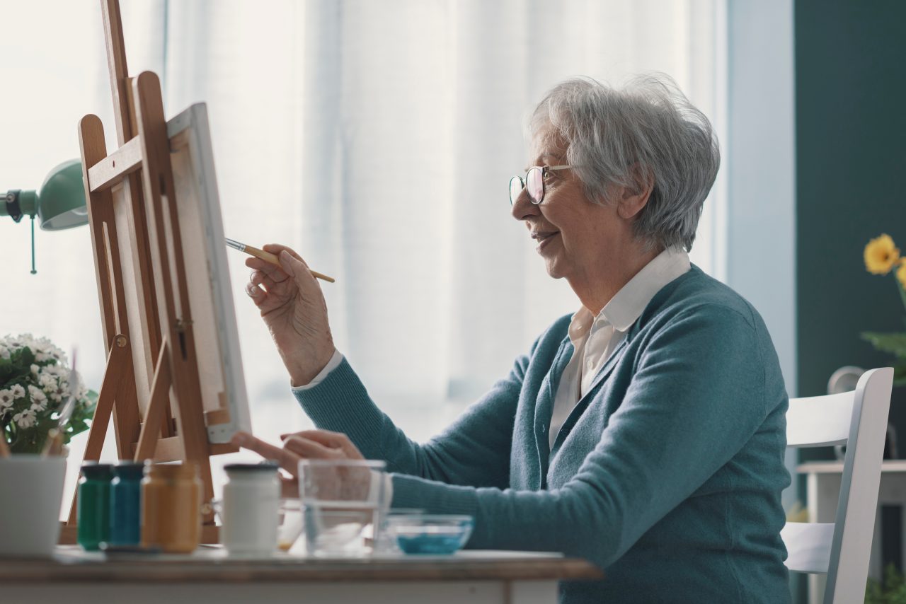 Senior woman painting on canvas